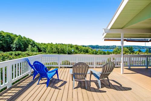 three chairs and a table on a deck at Home on Holmes in Freeland