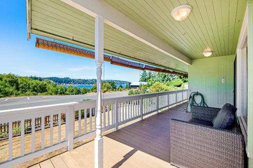 a porch with two wicker chairs and a view of a road at Home on Holmes in Freeland