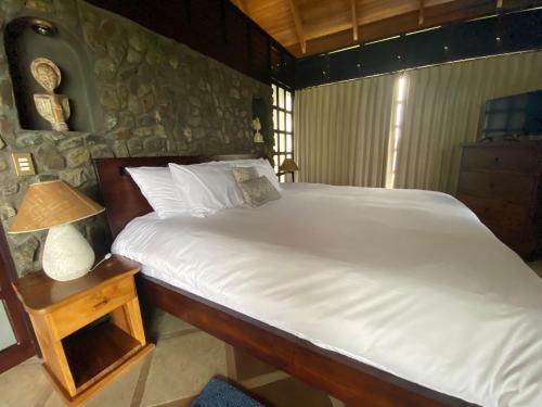 a bedroom with a bed and a table with a lamp at Tropical Balinese Villa Atenas in Escobal