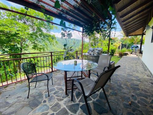 a table and chairs on a patio with a view at Tropical Balinese Villa Atenas in Escobal