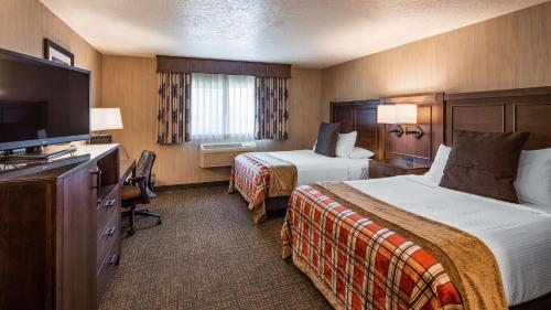 a hotel room with two beds and a flat screen tv at Best Western Plus Flathead Lake Inn and Suites in Kalispell