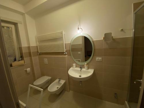 a bathroom with a sink and a mirror and a toilet at AFFITTACAMERE POPLETUM in Coppito