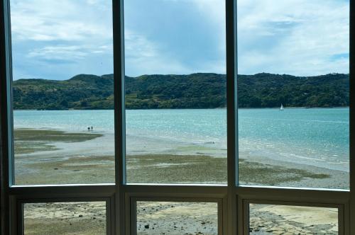 a view of a beach from a window at The Silos Apartments in Raglan