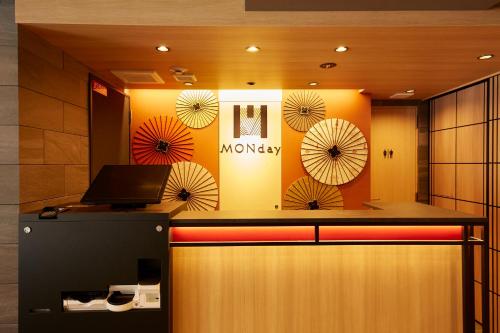 a lobby with a counter with a laptop on it at MONday Apart Premium KYOTO Station in Kyoto