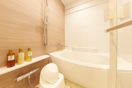 a bathroom with a toilet and a bath tub at MONday Apart Premium KYOTO Station in Kyoto