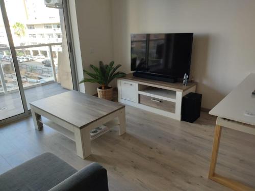 a living room with a tv and a coffee table at Algarve Sun Apartment in Portimão