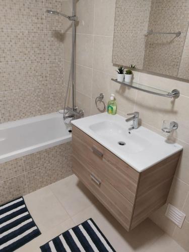 a bathroom with a sink and a bath tub at Algarve Sun Apartment in Portimão