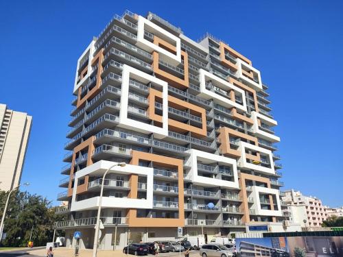 a tall apartment building with white and orange balconies at Algarve Sun Apartment in Portimão