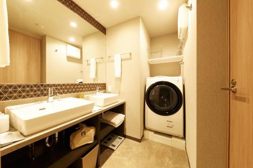 a bathroom with two sinks and a washing machine at MONday Apart Premium KYOTO Station in Kyoto
