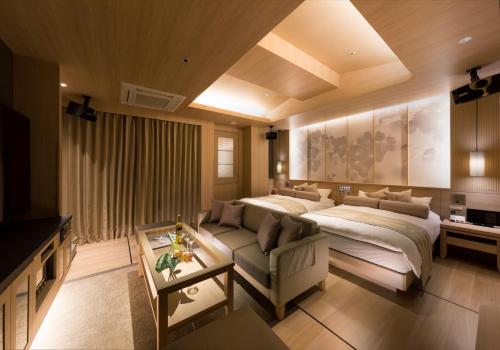 ein Schlafzimmer mit einem Bett und einem Sofa in einem Zimmer in der Unterkunft HOTEL SWEET SEASON-L in Ginan