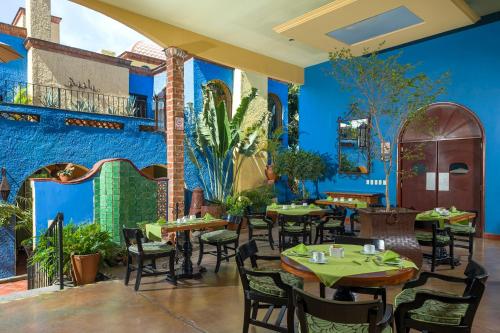 a restaurant with tables and chairs and a blue wall at La Villa del Ensueno Boutique Hotel in Guadalajara