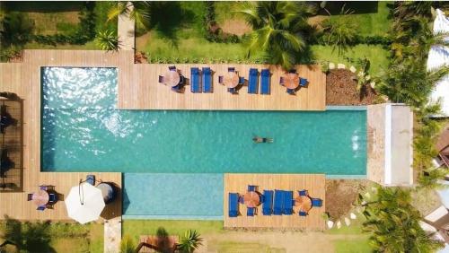 una vista aérea de una piscina con personas sentadas en sillas en Barra Grande Condomínio de Alto Padrão na Vila en Barra Grande