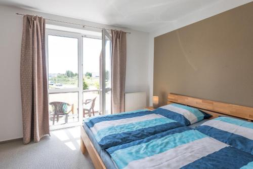 a bedroom with a bed and a window with a balcony at Hafenflair in Husum