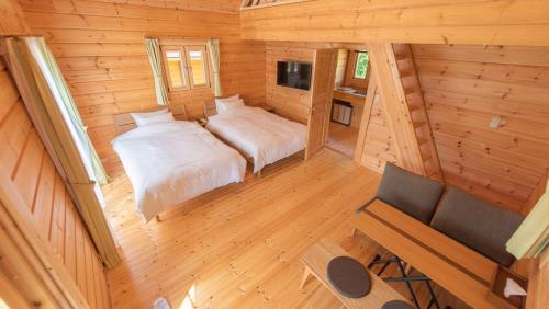 einen Blick über ein Schlafzimmer in einem Blockhaus in der Unterkunft ロガシス石垣野底ヴィラ in Ibaruma