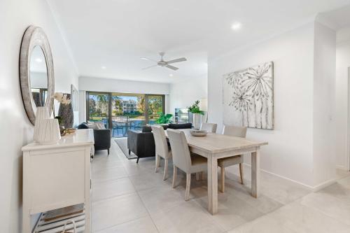 a dining room and living room with a table and chairs at Culgoa Point Beach Resort in Noosa Heads