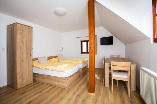 a bedroom with a bed and a desk and a table at Penziony Hnanice in Hnanice