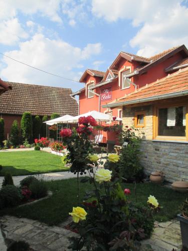 a garden in front of a house with flowers at Vila Boska Palic in Palić