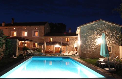 uma piscina em frente a uma casa à noite em Villa Barbara - Orihi em Barban