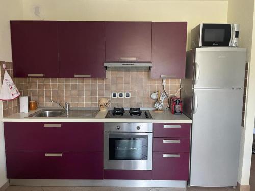 a kitchen with purple cabinets and a white refrigerator at Belle Vue de St Gervais in Saint-Gervais-les-Bains