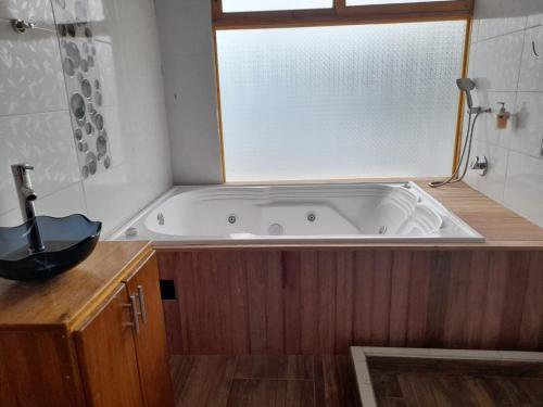 a bath tub in a bathroom with a window at Cabañas de descanso, arcoiris del lago 1 in El Encano