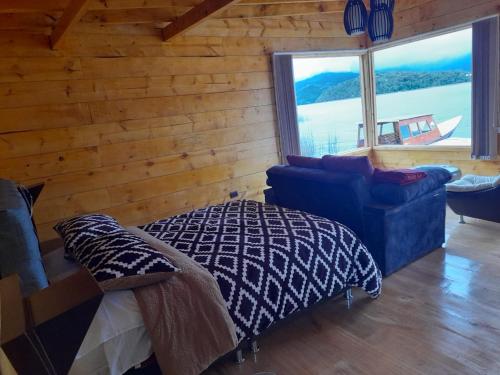 a bedroom with a bed and a couch and a window at Cabañas de descanso, arcoiris del lago 1 in El Encano