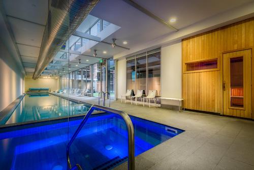 a swimming pool in a building with a large window at Milano Serviced Apartments in Melbourne