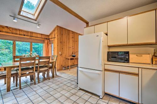 a kitchen and dining room with a table and a refrigerator at Spacious Dover Home with Sauna Less Than 5 Miles to Ski! in Dover