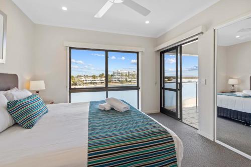 a bedroom with a bed and a view of the ocean at Culgoa Point Beach Resort in Noosa Heads