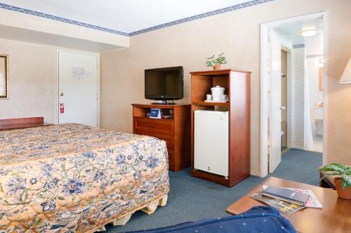 a hotel room with a bed and a tv at Saga Motor Hotel Pasadena in Pasadena