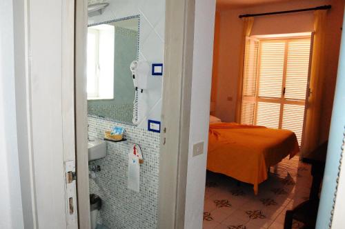 a bathroom with a sink and a bed in a room at Hotel Belsole in Ischia
