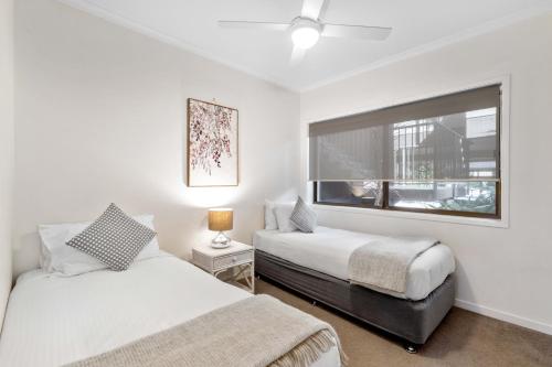 a bedroom with two beds and a window at Culgoa Point Beach Resort in Noosa Heads