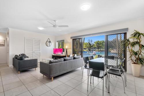 a living room with a couch and a table and chairs at Culgoa Point Beach Resort in Noosa Heads