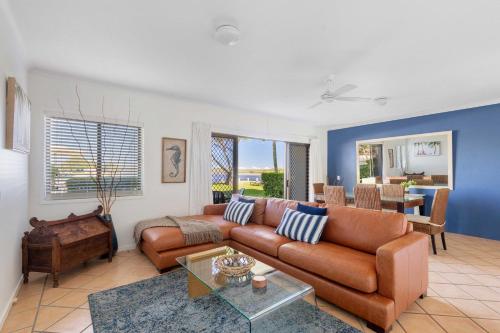 a living room with a couch and a table at Culgoa Point Beach Resort in Noosa Heads