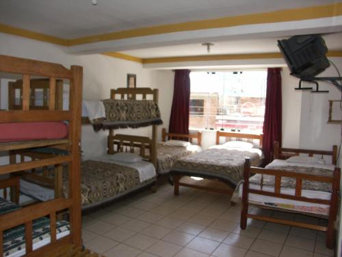 a room with three bunk beds and a window at La Cabaña in Huaraz