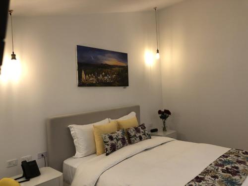 a bedroom with a bed and a painting on the wall at Adamas House Hotel Boutique in Quito