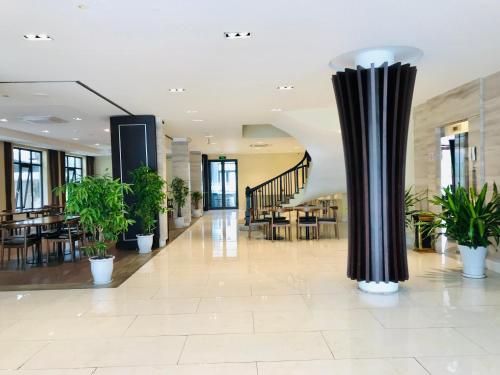 a lobby with potted plants and a column at Lagalo Hotel Ha Nam in Phủ Lý
