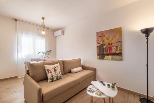 uma sala de estar com um sofá e uma mesa em BnS Triunfo Centro Suites em Granada