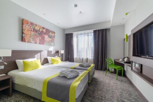 a hotel room with a large bed and a tv at Art Moscow Voykovskaya in Moscow