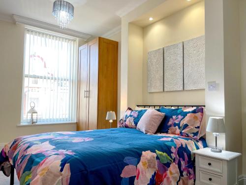 a bedroom with a bed with a blue comforter at Stylish apartment with free parking, lift & views in Scarborough