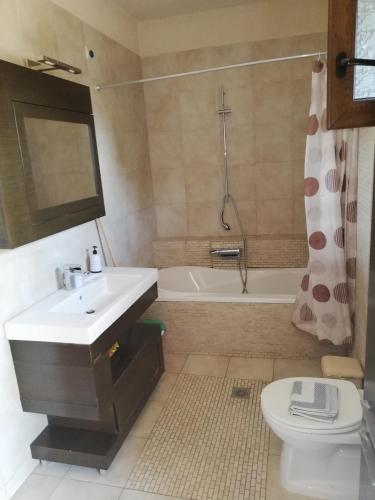 a bathroom with a sink and a toilet and a tub at Villa Elva in Asprovalta