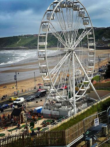 a large ferris wheel on a beach next to a beach at Stylish apartment with free parking, lift & views in Scarborough