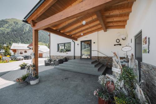 a house with a staircase and a wooden roof at Hotel Alpina in Galtür