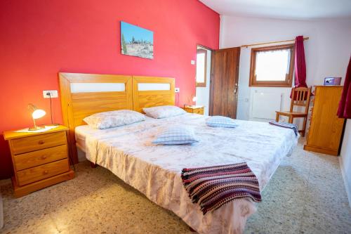 1 dormitorio con cama grande y pared roja en Casa Marena, en Puntagorda