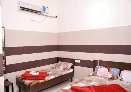 two beds in a room with striped walls at Asha Guest House in Amritsar