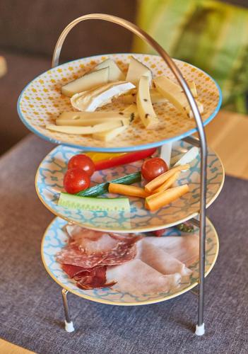 two plates of food on a rack with vegetables at Fuchs und Gretl in Saalbach Hinterglemm