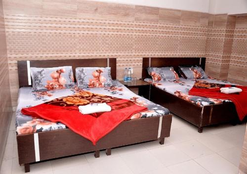 two twin beds in a room with at Asha Guest House in Amritsar