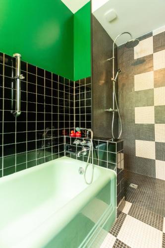 La salle de bains est pourvue d'une baignoire et d'un mur vert. dans l'établissement GITE Du MISFON 