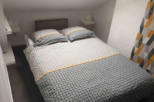 1 cama con 2 almohadas en una habitación en Appart Cosy Annœullin - Proche toutes commodités en Annoeullin