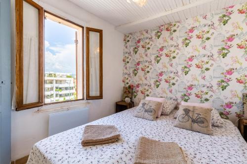 une chambre avec un lit avec un papier peint fleuri dans l'établissement THE CREW HOUSE LA CIOTAT - Maison de pêcheur en triplex 3 chambres et box privatif au dessus du Vieux Port, à La Ciotat