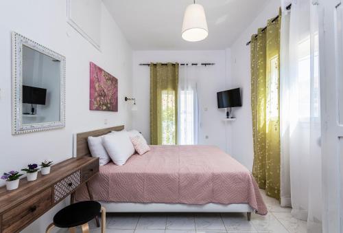 Stenorimi Valley House - Livadi, Astypalea في ليفاذيا أستيبالياس: غرفة نوم بسرير وبطانية وردية